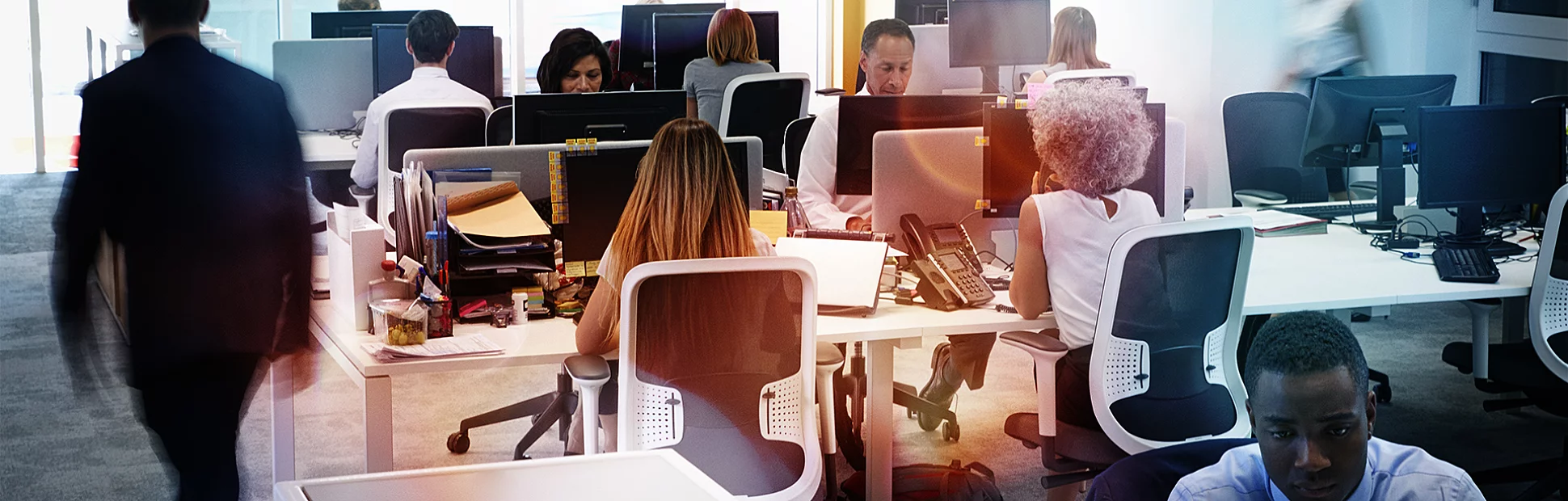Man walking through a busy open plan office