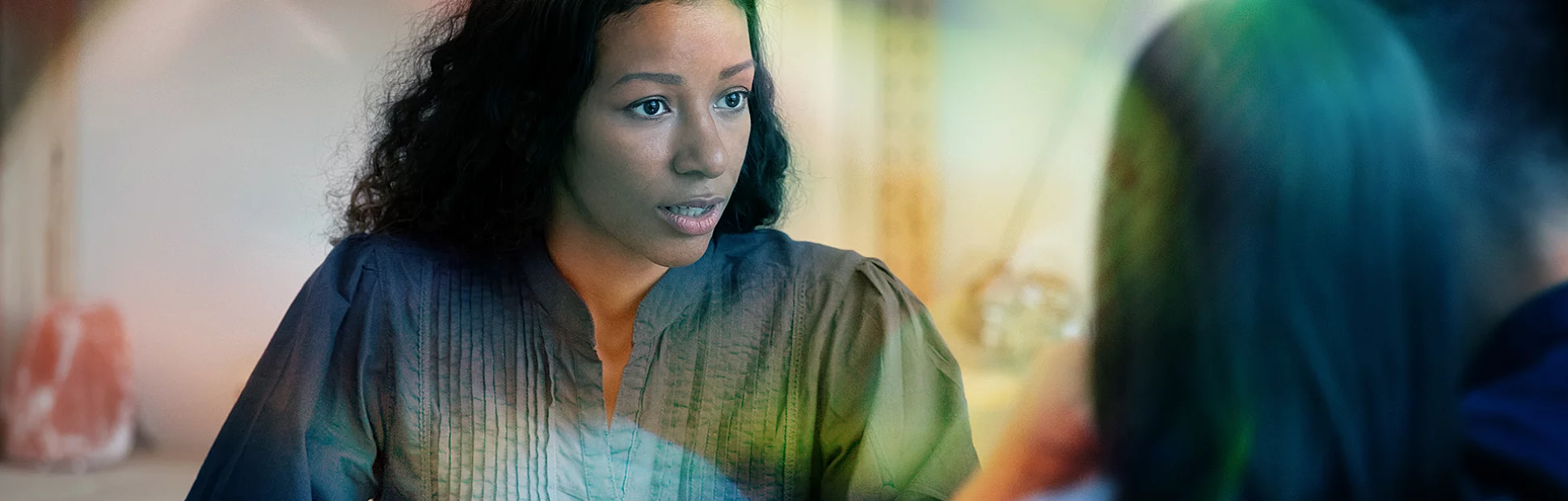 Focused African American female real estate agent or architect talk with young couple at meeting