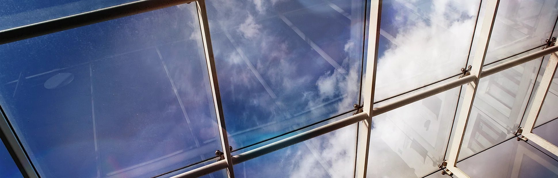 Close up of a glass roof and blue sky