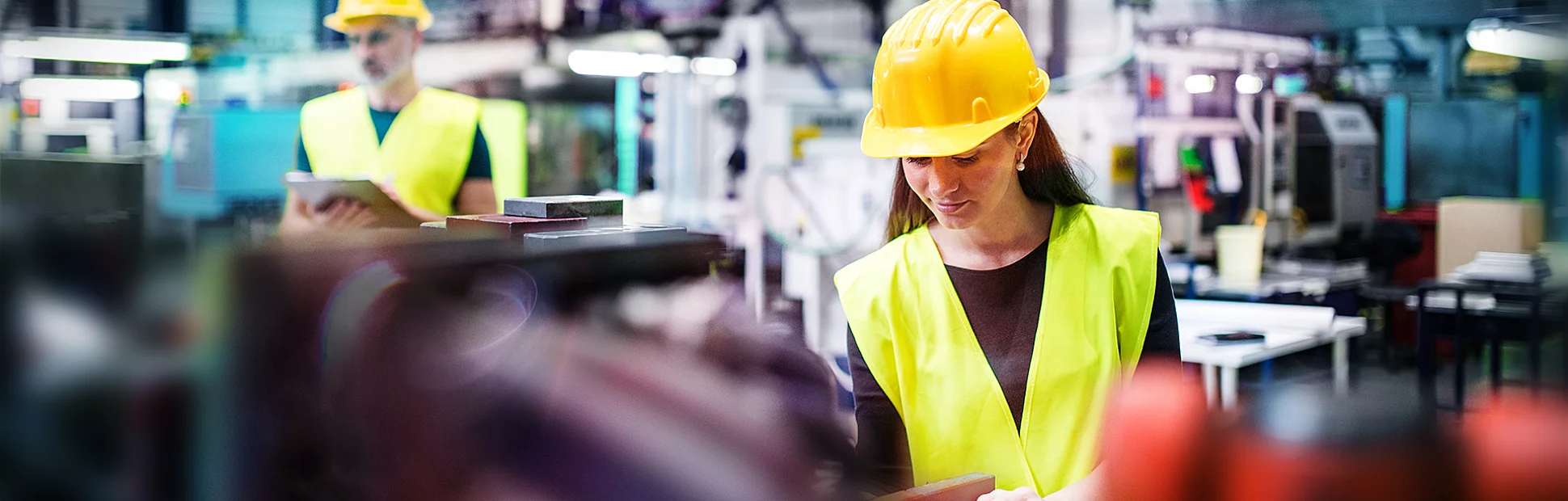 Two employees working on the floor of a factory