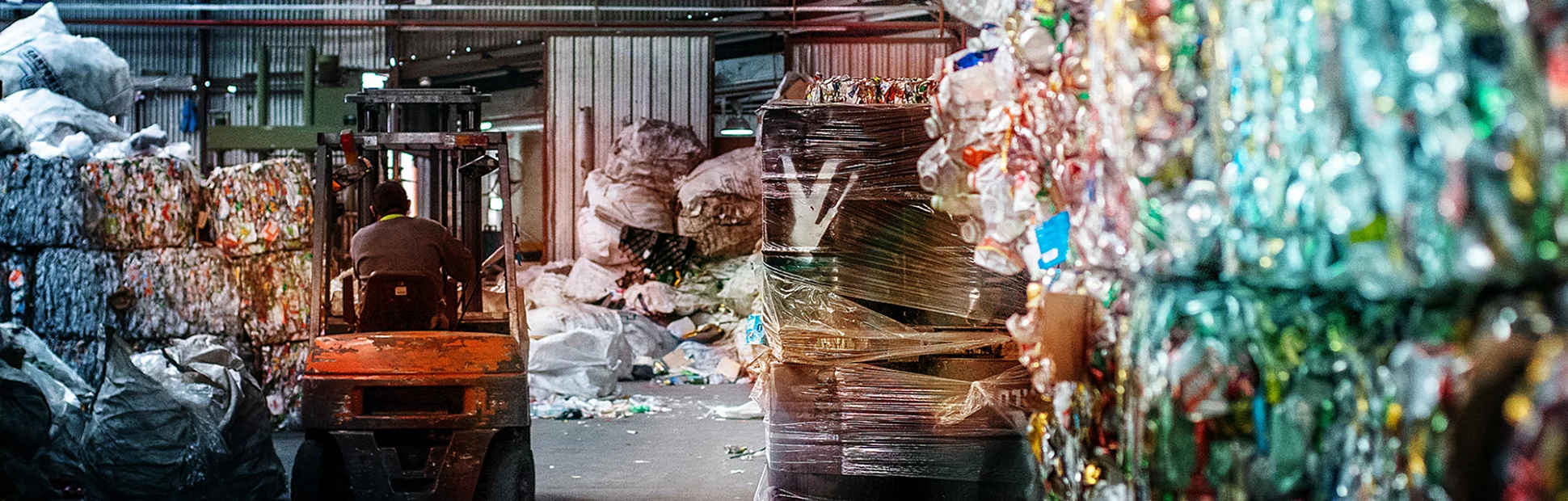 Interior of solid waste processing facility full of blocks and bags of recycling materials