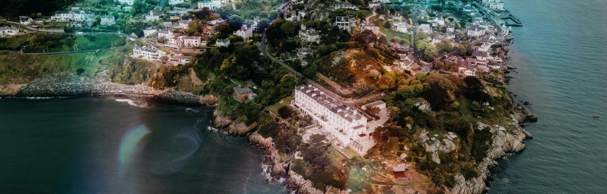 Ariel view of Sorrento Point, Dalkey, Ireland. Houses and buildings along rocky shoreline.