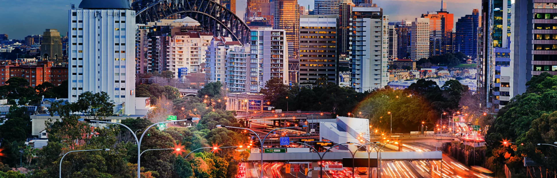 Busy highway at dusk with cityscape in the background