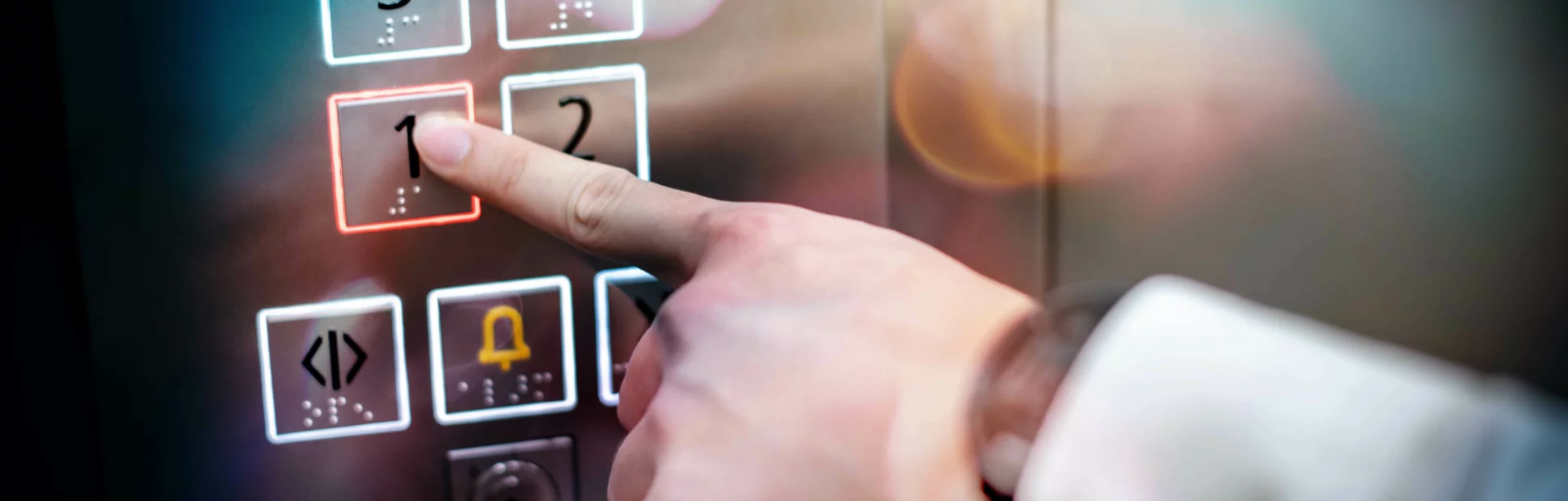 Male index finger pressing on the first floor button or floor number one in elevator (lift).