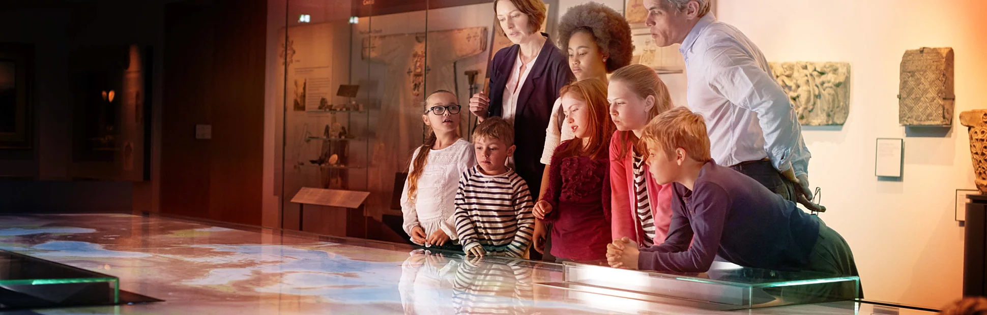 Pupils On School Field Trip To Museum Looking At Map