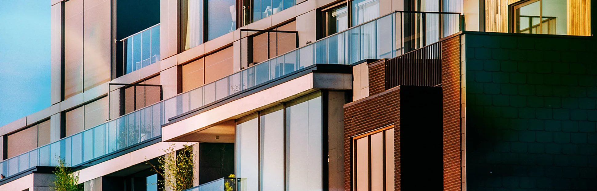 A modern facade of a block of apartments against a blue sky