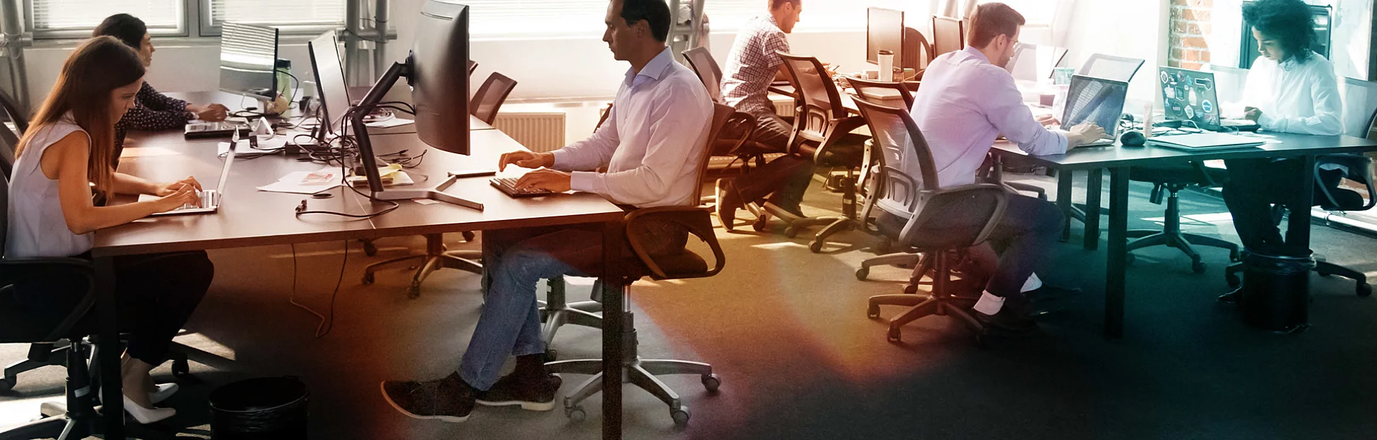  Busy coworkers using computers and chatting solving business matters in a contemporary office