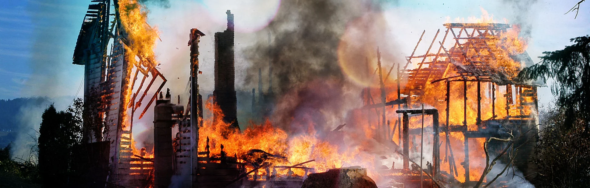 Old farm house completely consumed by fire is burnt to the ground.