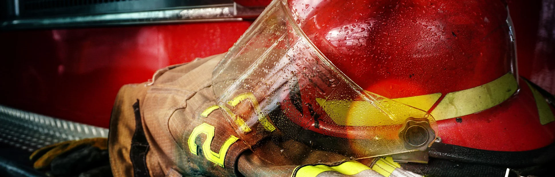 Firefighter protection gear, helmet, gloves on the bumper of the fire truck