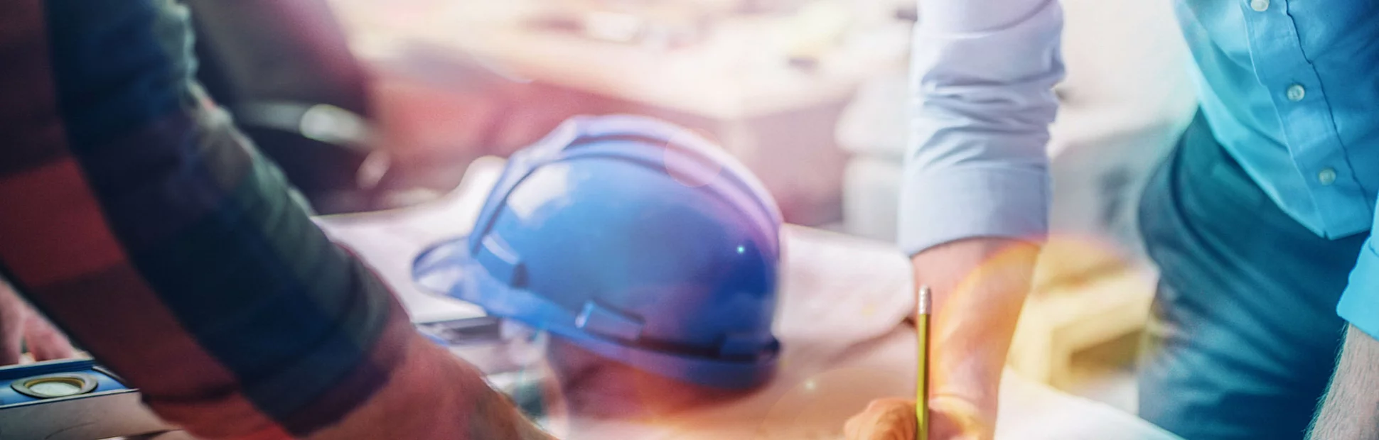 Hands of an architect and an engineer pointing at the architectural plan.