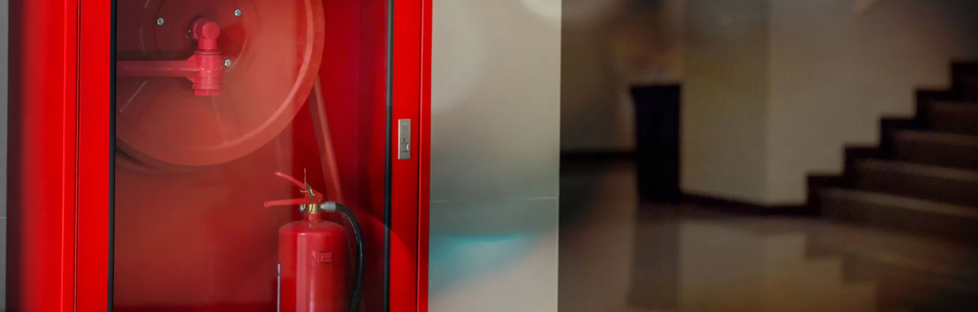 Hydrant with water hoses and fire extinguish equipment on wall cement .