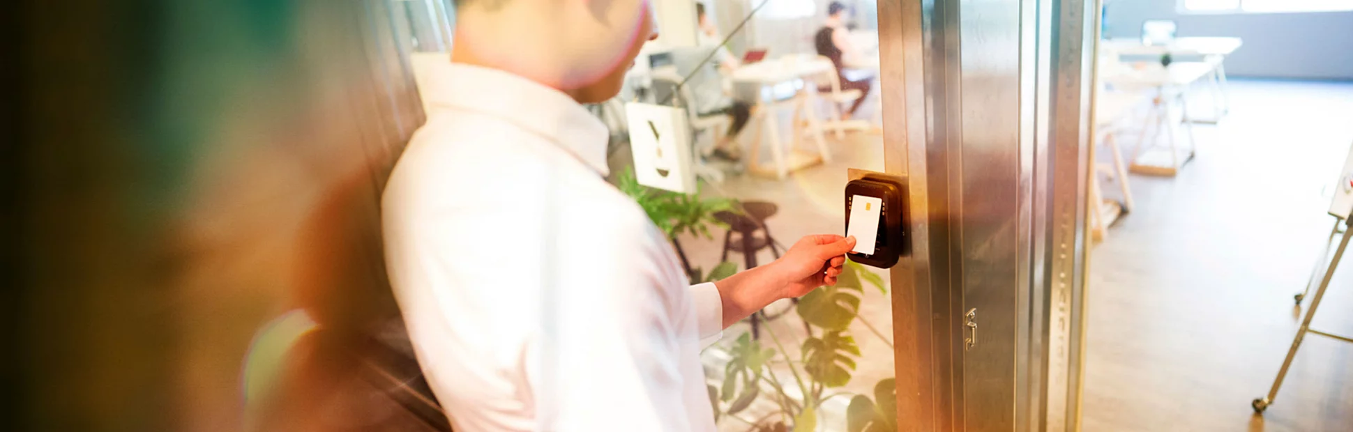 Young man unlocking door at his office with an electronic key card