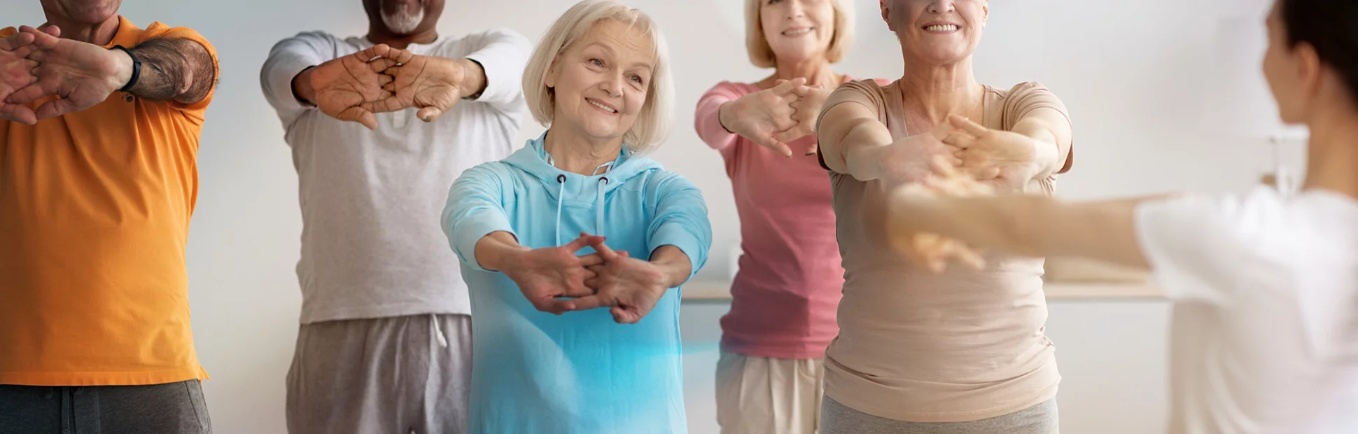 Sporty elderly people having fitness class, training with instructor