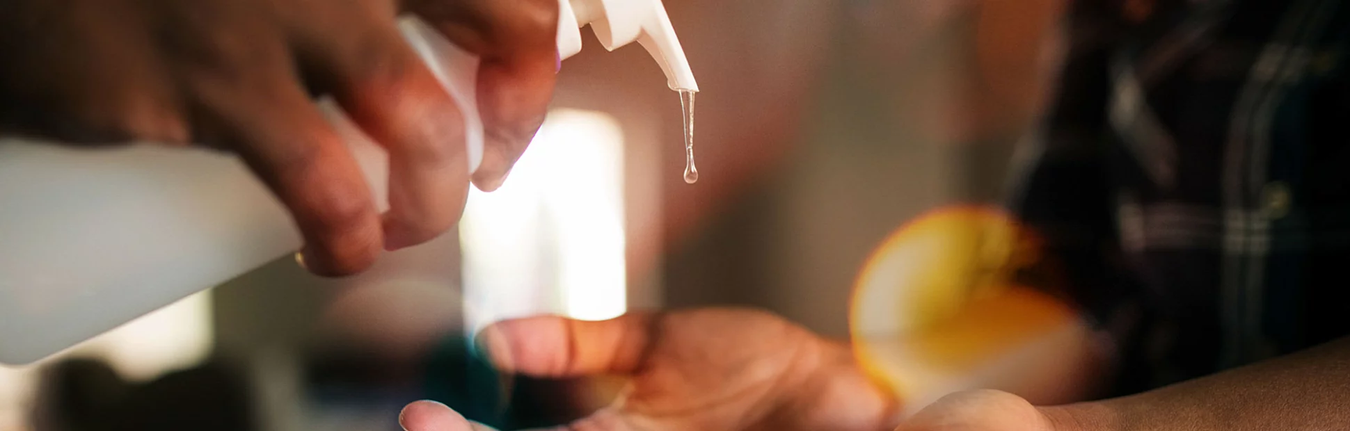 Man pumping out hand sanitizer into woman's hands
