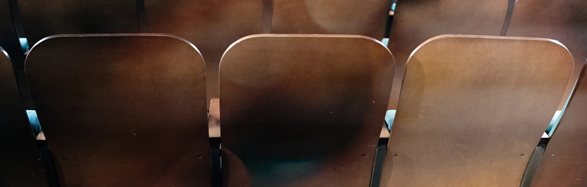 back of brown, wooden cinema or auditorium chairs
