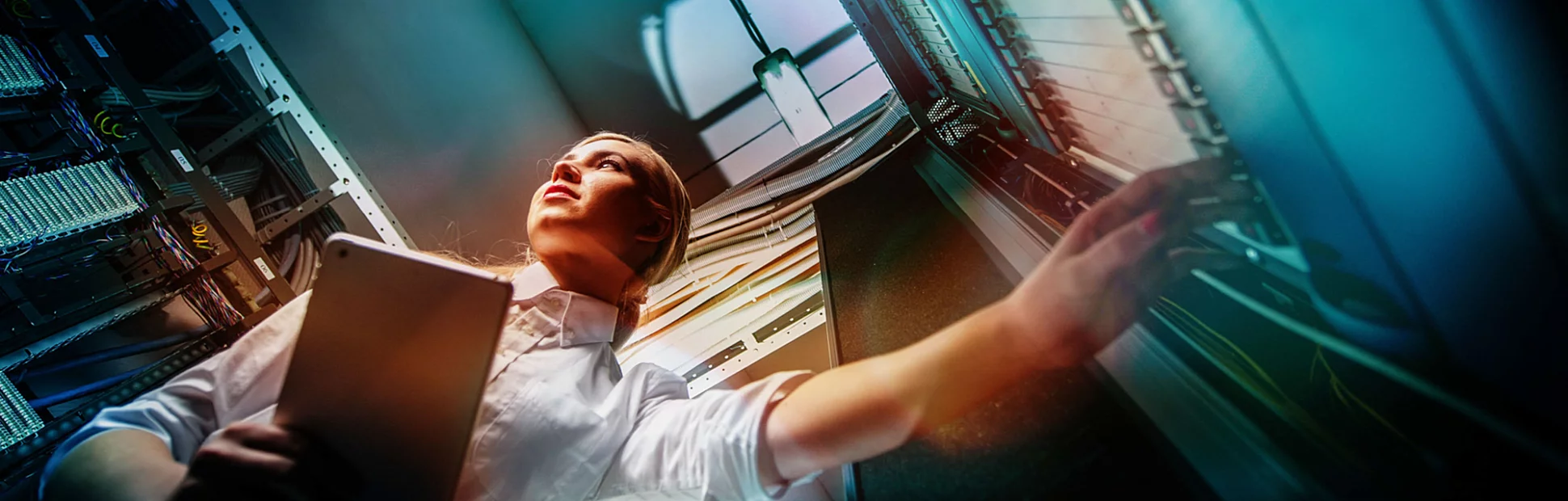 Young engineer businesswoman in network server room.