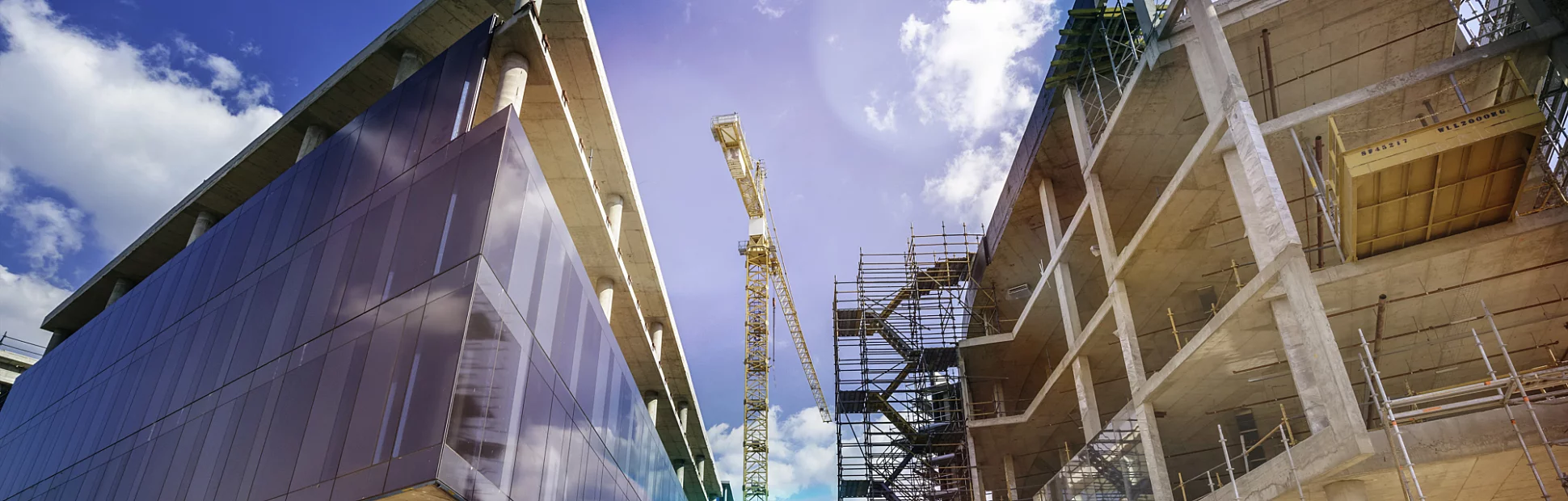 Construction crane at a mall retail centre building site seen at sunset