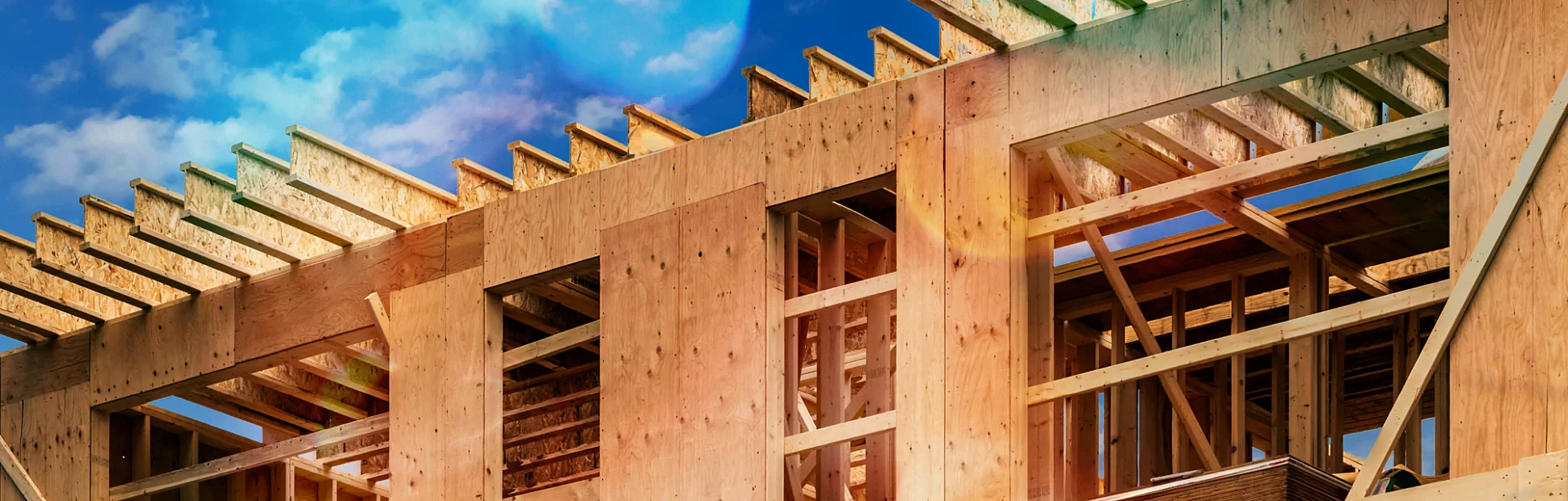 Plywood sheathing and engineered wood joists/rafters forming the roof of a house under construction