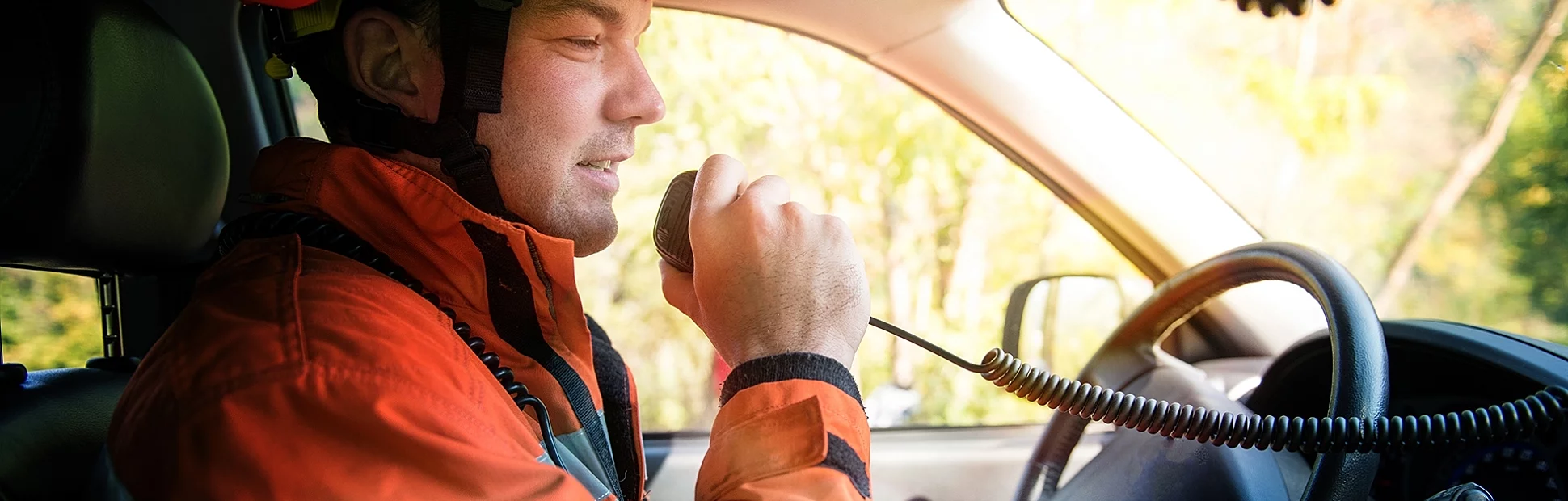 Firefighter in a fire truck using a handheld radio