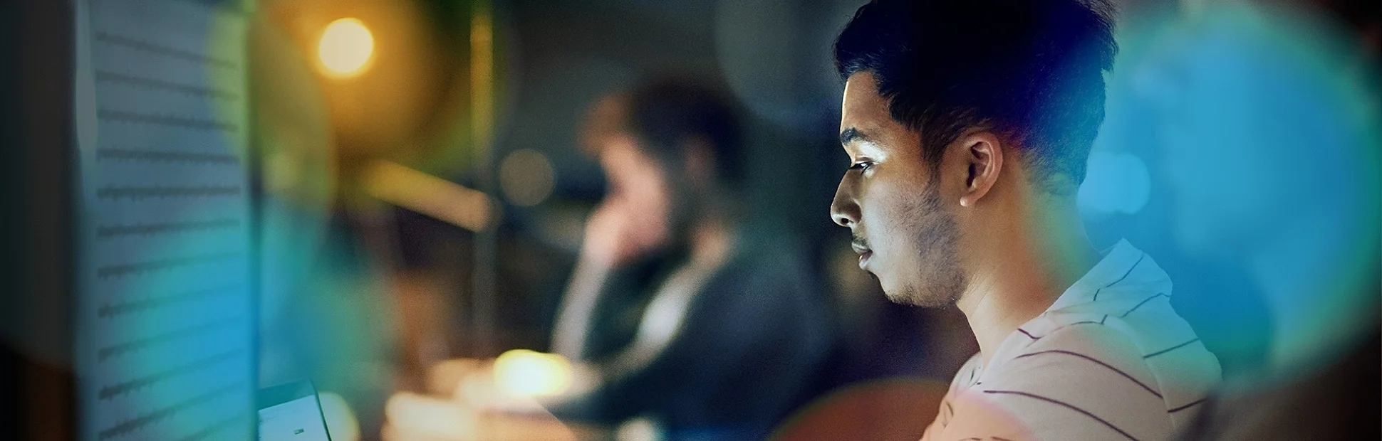 Shot of a young designer working late on a laptop and computer in an office
