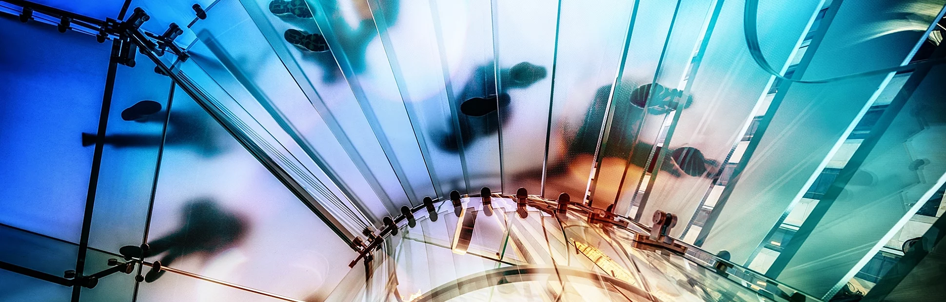 People walking on transparent glass spiral staircase in futuristic building, unrecognizable people.