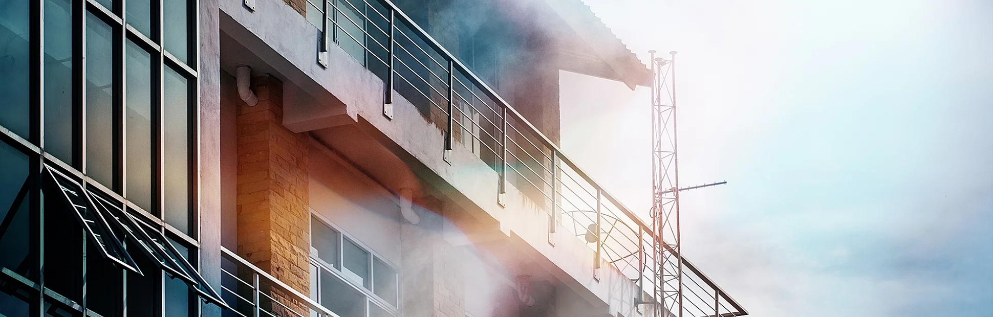 The smoke coming out of the front of the high building due to a fire.