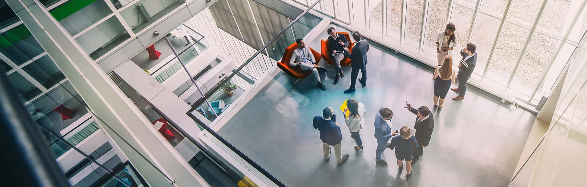 A high-angle view of a mixed age group of eleven business persons standing in the office building