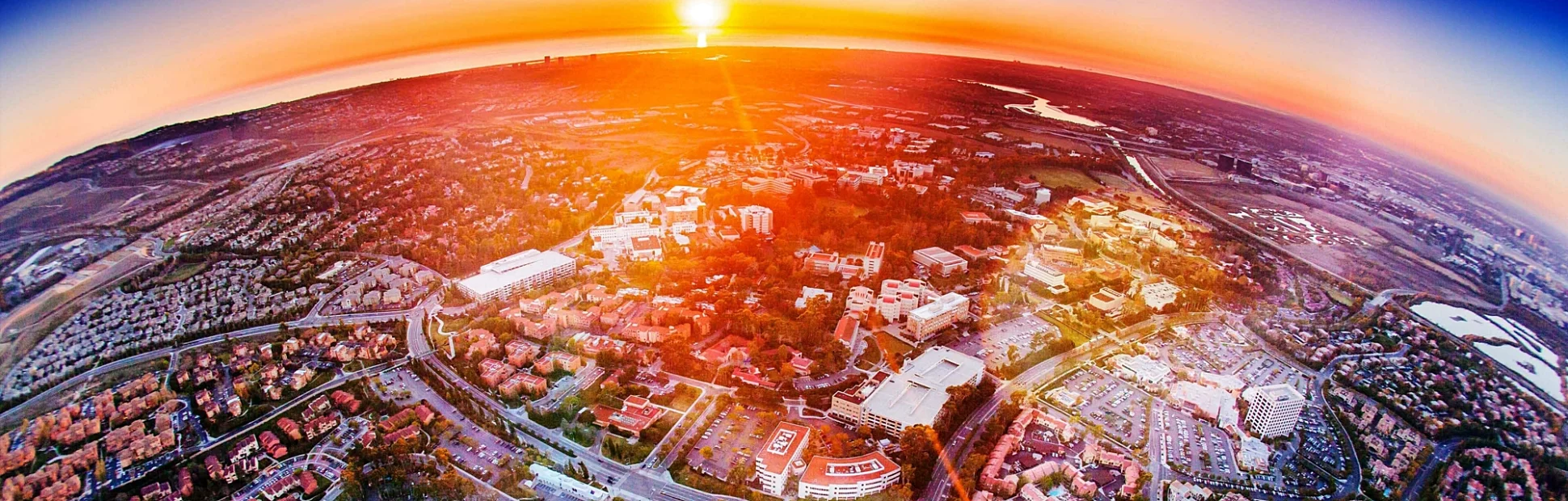An aerial view of homes and the California coast at sunset