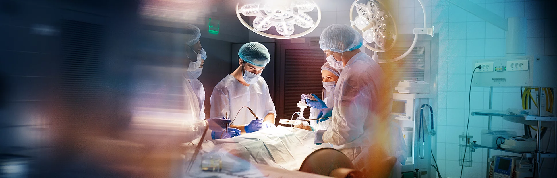 Blurred shot of group of professional surgeons at work in operating room.