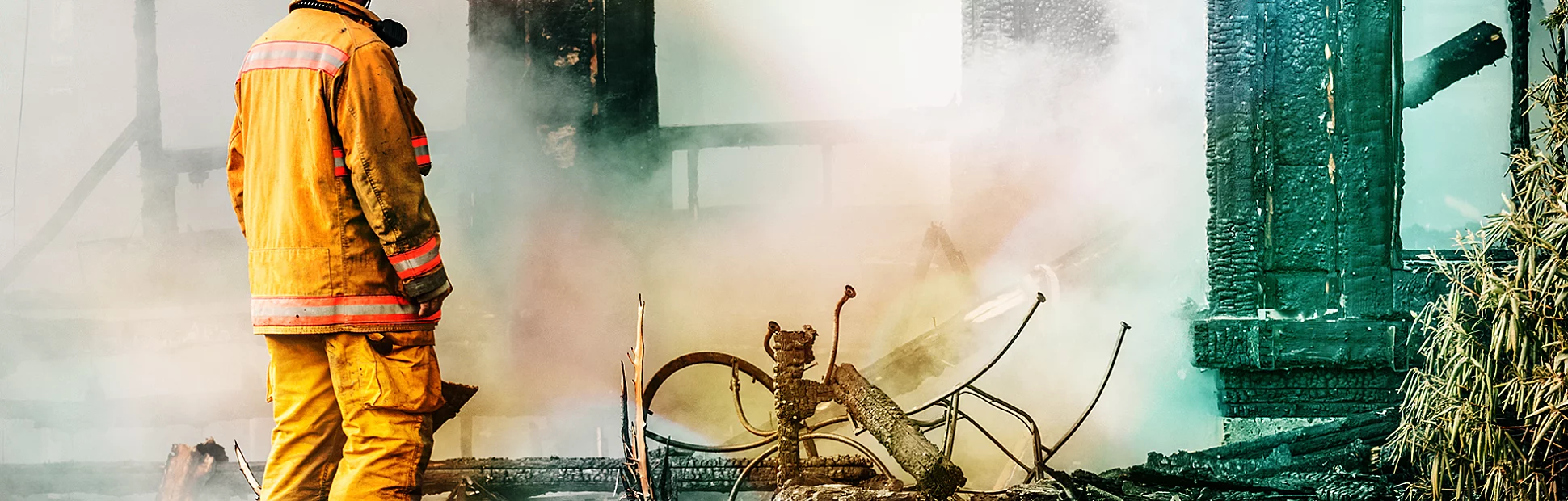 A firefighter investigates the devastation of a house fire.