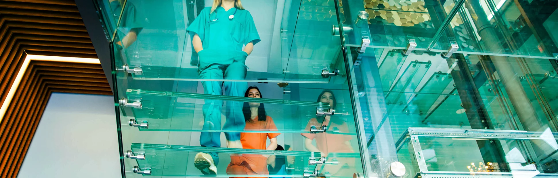 Medical professionals walking on modern glass staircases