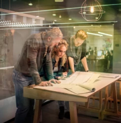 Group of creative people having a meeting in the office and working on blueprints.