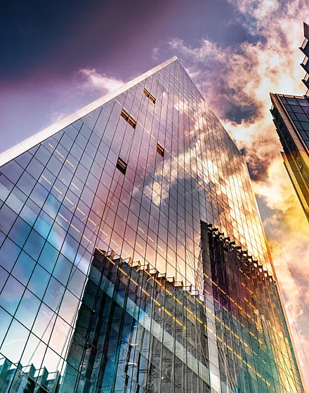 Bottom view of modern skyscrapers in business district in beautiful evening light at sunset
