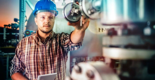 Man wearing blue hardhat using tablet at Natural gas processing facility