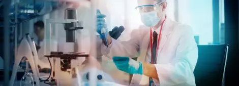 Scientist Wearing Face Mask Uses Micro Pipette Dropper to Mix Petri Dish Sample