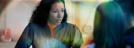 Focused African American female real estate agent or architect talk with young couple at meeting