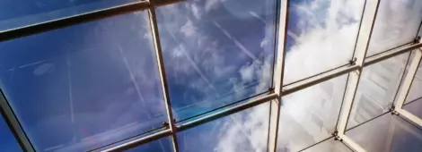 Close up of a glass roof and blue sky