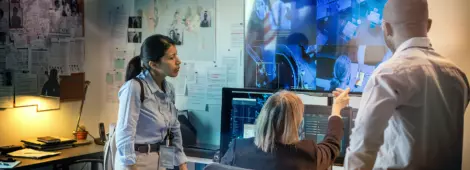 Head of safeguard department and her subordinates looking at security camera on a large screen