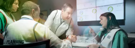 Group of people gathered around a table in a conference room setting.