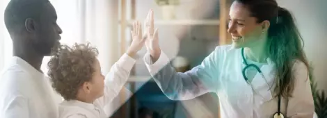Happy  little child boy gives high five to female doctor pediatrician at medical  appointment