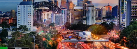 Busy highway at dusk with cityscape in the background