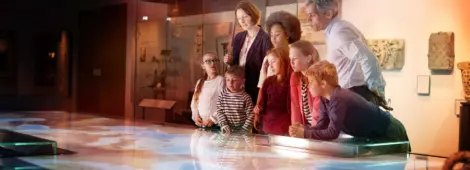 Pupils On School Field Trip To Museum Looking At Map