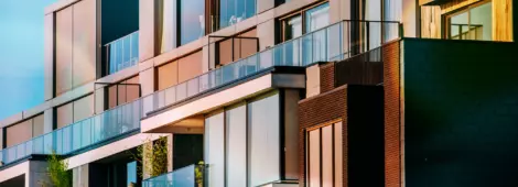 A modern facade of a block of apartments against a blue sky