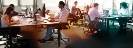 Busy coworkers using computers and chatting solving business matters in a contemporary office