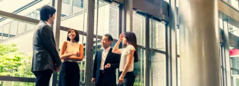 A group of business people gathered at the top of a flight of stairs