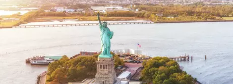 Aerial view of Statue of Liberty in Liberty Island and sunset. New York, USA