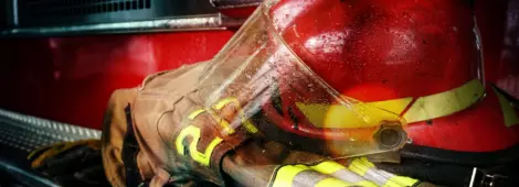 Firefighter protection gear, helmet, gloves on the bumper of the fire truck