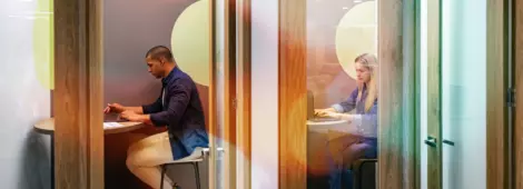 Business people working in private cubicles at a coworking office