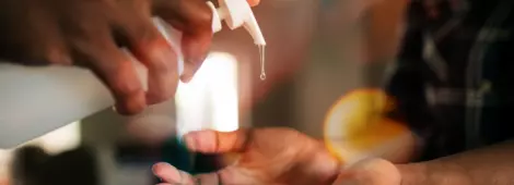 Man pumping out hand sanitizer into woman's hands