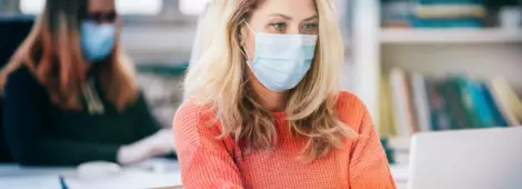 Colleagues in the office working while wearing medical face mask during COVID-19